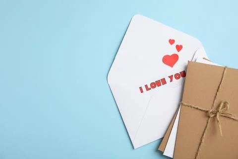 Love letter and stack of envelopes on light blue background, flat lay. Space  Stock Photos