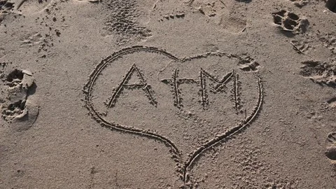 A love message written in the sand on a beach by the sea. Stock Footage 297008096