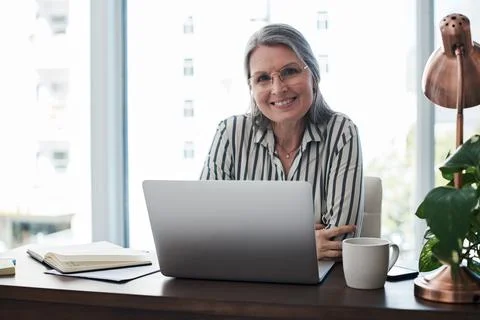 Love or hate me, doesnt make or break me. Mature businesswoman using her laptop Stock Photos