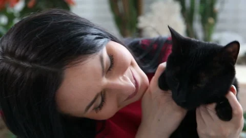 Love for pets. beautiful dark-haired girl with a black cat is relaxing at home Stock Footage 90640196