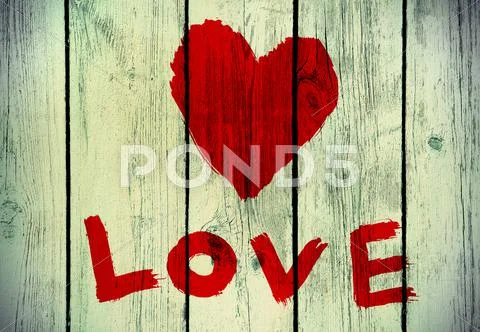 Love symbol on old wooden wall Stock Photos