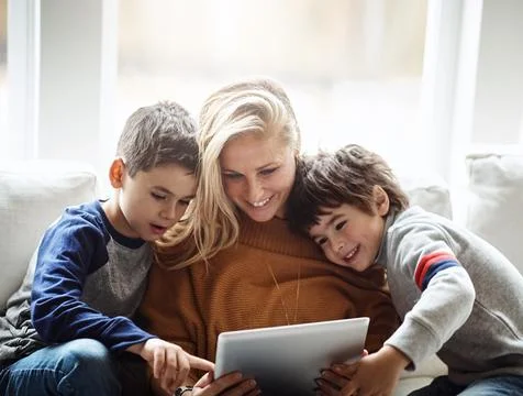 Love, tablet and mother with children on sofa bonding, quality time and relax on Stock Photos