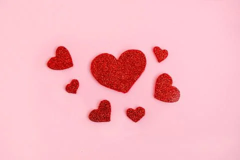Love theme background with red glitter handmade hearts on pink background Stock Photos