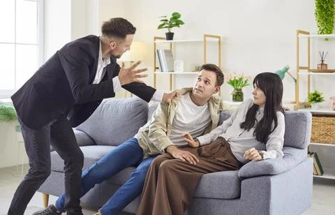 Love triangle confrontation with angry man exposing betrayal and infidelity Stock Photos
