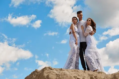 A love triangle, a man posing with two young girls in white dresses, friendsh Stock Photos