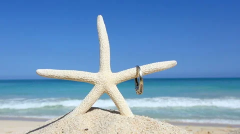 Love wedding concept Engagement ring and starfish on tropical beach Oahu Stock Footage 62906187