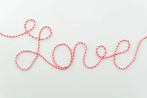 Love word written with woolen thread lettering, concept and background for Stock Photos