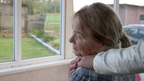 A loved one puts his hand on the shoulder of an elderly woman Stock Footage 287209063