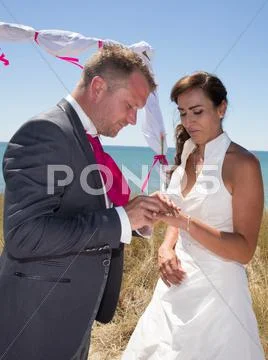 Lovely and cheerful wedding couple exchanging rings Stock Photos
