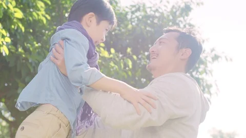 Lovely asian boy running toward father in park Stock Footage