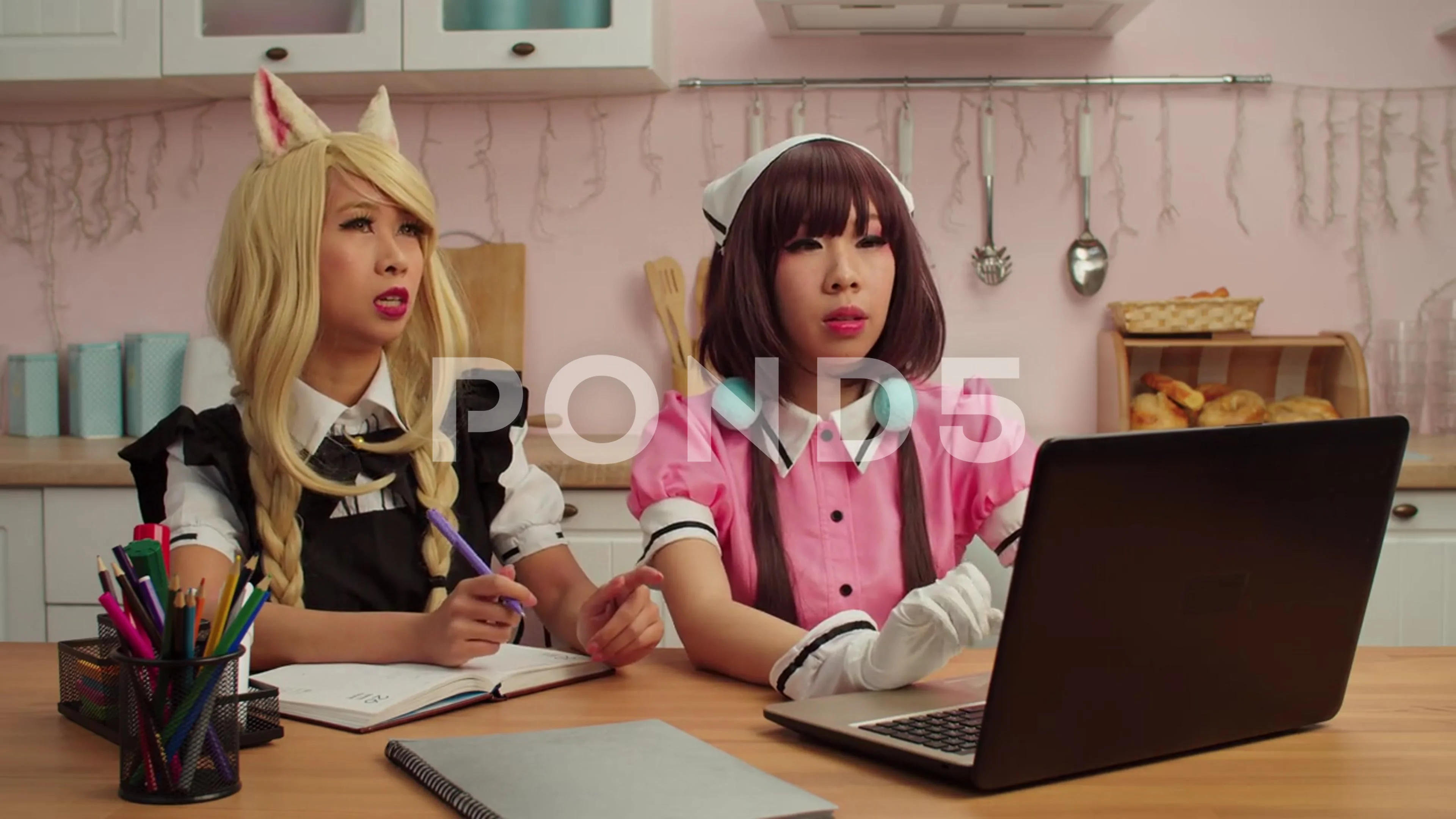 Lovely Asian female cosplayers with laptop planning cosplay performance at home