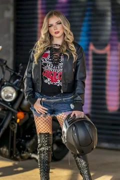 A Lovely Blonde Model Poses Outdoors With Her Motorcycle In A Large City E... Stock Photos