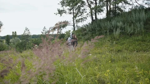 Lovely couple with backpack walks on the path of field nature Vídeo Stock 121682307