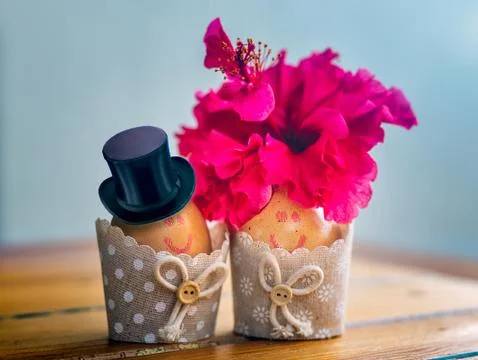 Lovely couple of Easter eggs with drawn faces, decorated with hat and hibiscus Stock Photos