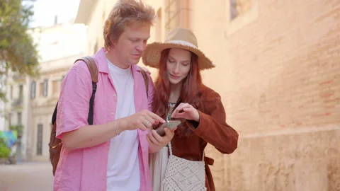 A lovely couple joyfully exploring a charming and vibrant street on a bright Stock Footage 283293507