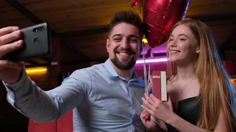 Lovely couple making a selfie while he gave her a present and air balloons 스톡 동영상 150138967