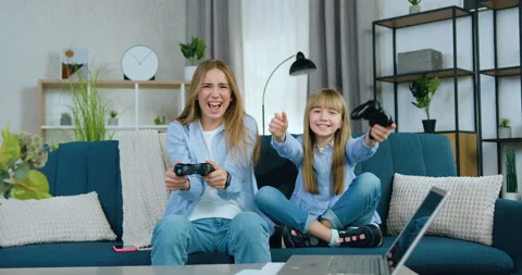 Lovely friendly cheerful two different ages girls playing video games using Stock Footage 149744812