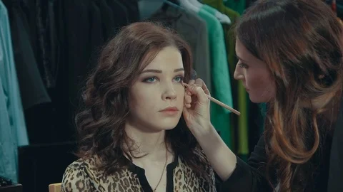 Lovely girl does evening make-up for her girlfriend in the room. Stock Footage 74080533