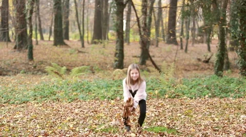 Lovely girl throwing leaves and spinning around in park Stock Footage 59554389