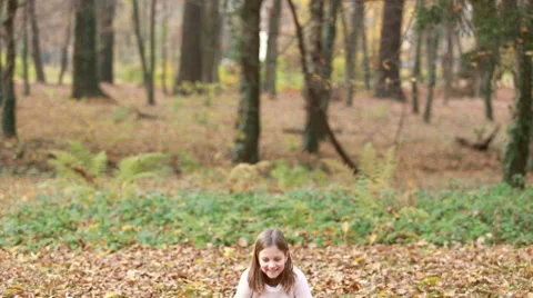 Lovely girl throwing leaves and jumping in park Stock Footage 59554390