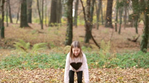 Lovely girl throwing leaves and jumping in park Stock Footage 59554391