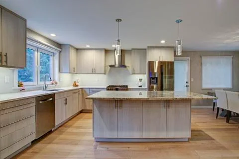 Lovely kitchen room interior features ivory cabinets accented with lucite pul Stock Photos