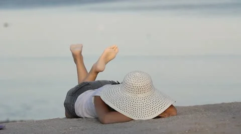 Lovely lady laying down on beach sand playing with her feet Video stock 12272465