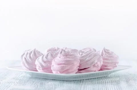Lovely pastel rose meringues, zephyrs, marshmallows on the wooden vintage table Stock Photos