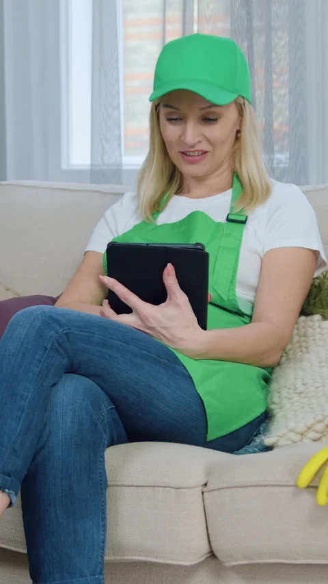 Lovely smiling happy light haired female worker of cleaning service resting on s Stock Footage 327874249