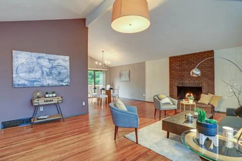 Lovely spacious open floor plan with vaulted ceiling and tan walls features l Stock Photos