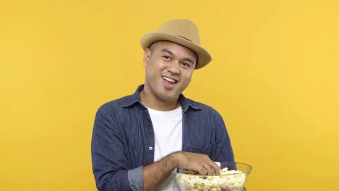 A lovely young man put on hat eats popcorn while watching something romantic iso Stock Footage 144663124