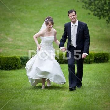 Lovely young wedding couple - freshly wed groom and bride posing Stock Photos