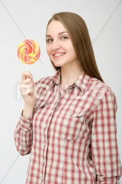 Lovely young woman fooling around, licking lolipop, isolated on white background Stock Photos