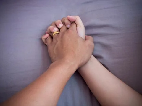 Lover hands on bed Stock Photos