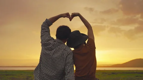 Lover sitting in the meadow at sunset in the evening time Stock Footage 156602795