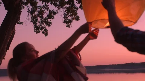 Lovers are launching sky lantern at sunset Stock Footage 98920880