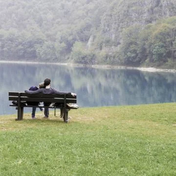Lovers on the bench in front of the lake Stock Photos