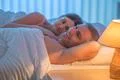 The lovers couple lie on the bed. Evening night time Photo