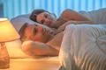 The lovers couple lie on the bed. Evening night time Photo