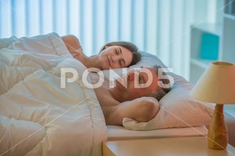 The lovers couple sleeping on the bed Stock Photos