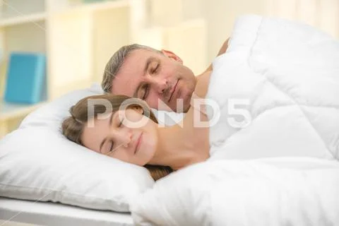 The lovers couple sleeping on the bed Stock Photos