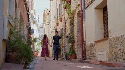 Lovers couple walking holding hands and smiling in old town of Antibes, France 库存影片 116951981