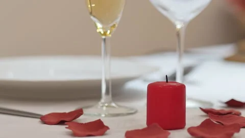 Lovers day dinner table: man waiter or lover lighting up a red love candle for Stock Footage 146205978