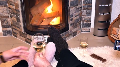 Lovers drink white wine in front of the fireplace Stock Footage 100755182