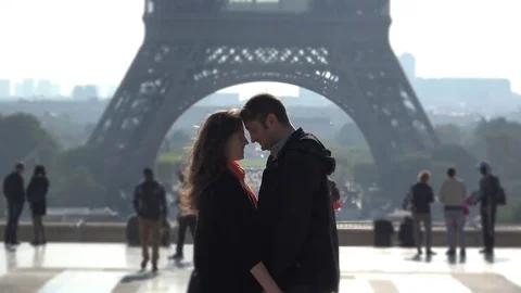 Lovers embrace in front of Eiffel tower, people passing  Stock Footage 69181471