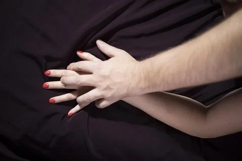 Lovers' hands squeeze each other in bed, romantic and passionate make love Stock Photos