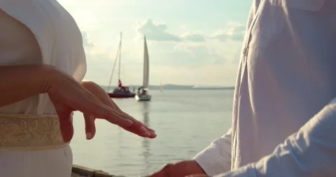 Lovers hold hands on the dock Видео 156553590