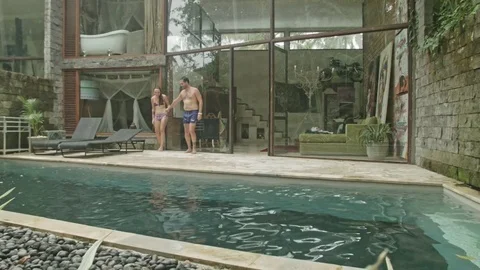 Lovers jump into the pool on Bali Stock Footage