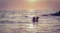 Lovers kissing in the sea at sunset - love - man and woman kiss HD Footage