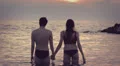 Lovers kissing in the sea at sunset - love - man and woman kiss - holding hands HD Footage